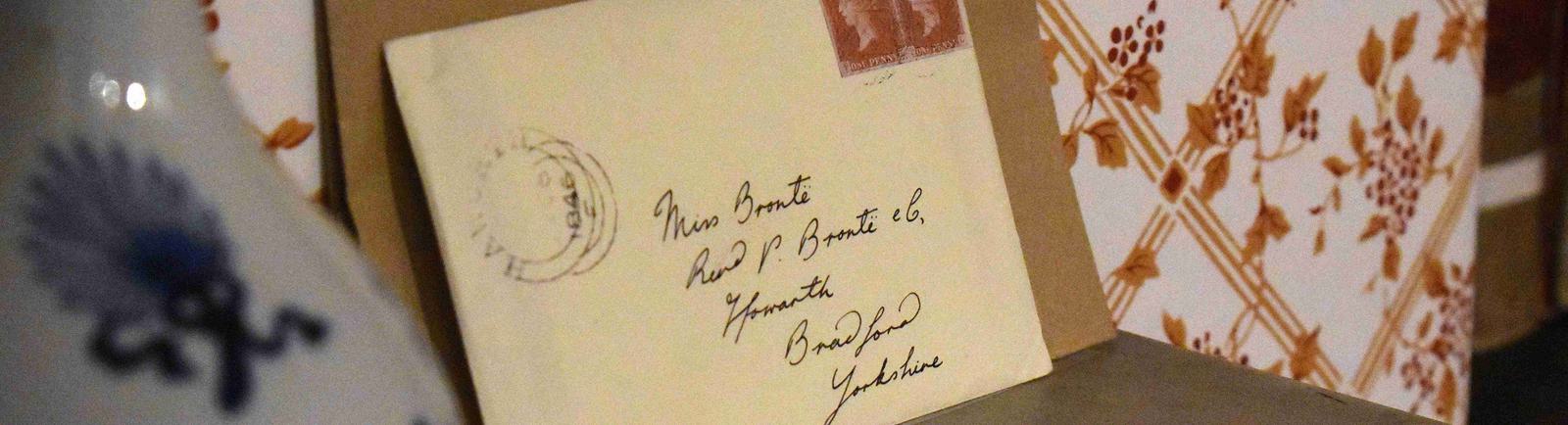 Photo of a Victorian letter addressed to 'Miss Bronte', propped up on a shelf.