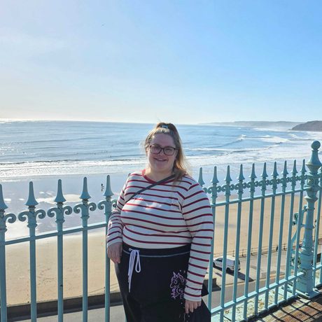 A woman standing by a beach.