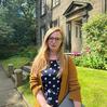 Photo of a smiling woman with fair hair outside the Bronte Parsonage Museum.