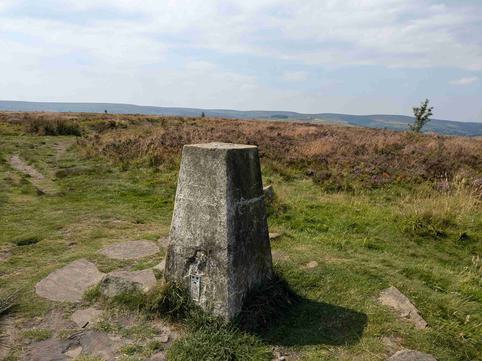 Photo of a stone trig point surrounded by moorland.