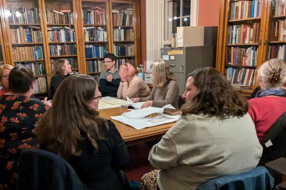 People sat in the research library looking at artifacts.