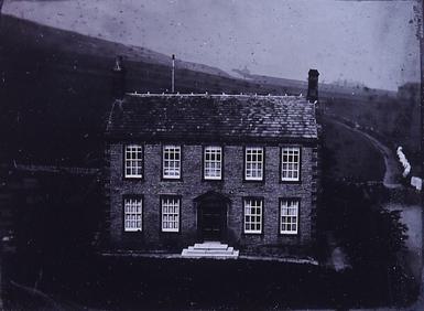 Black and white photo of Haworth Parsonage - a symmetrical, 18th-century house.