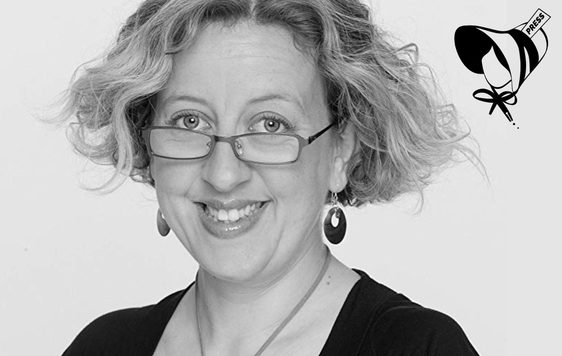 Black and white image of a woman wearing glasses and smiling.