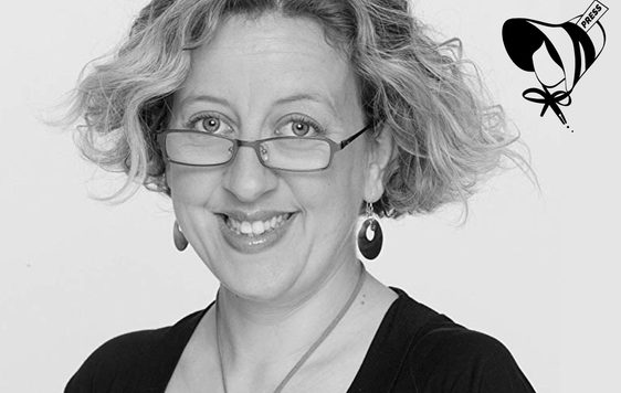 Black and white image of a woman wearing glasses and smiling.