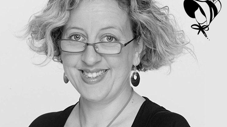 Black and white image of a woman wearing glasses and smiling.