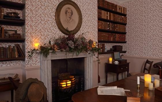 The Dining room lit by candlelight and plants around the fireplace.