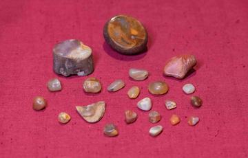 Photo of a collection of shiny stones against a red background.