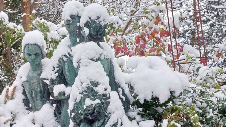 Photo of a snowy statue of three women.