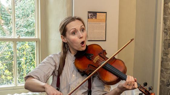 Photo of a woman wearing braces and playing the violin.
