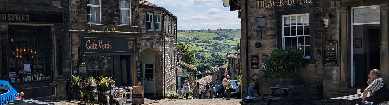 Photo of a cobbled street on a sunny day, with 18th-century buildings either side.